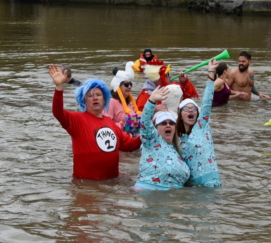 Two participants in the bitter cold swim scream and wave to their friends and family.